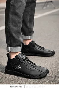 Close-up of black hand-stitched leather casual shoes worn with jeans on urban street