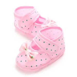Detailed view of pink polka dot baby shoes with decorative bow and soft sole
