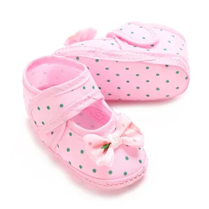 Sweet pink polka dot baby shoes with soft soles and a charming striped bow accent