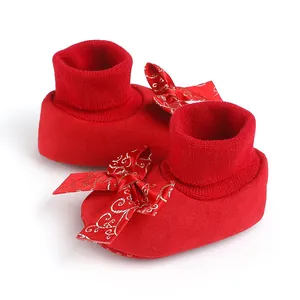 Detailed view of festive red baby pre-walker shoes with elegant bow and soft knit cuff