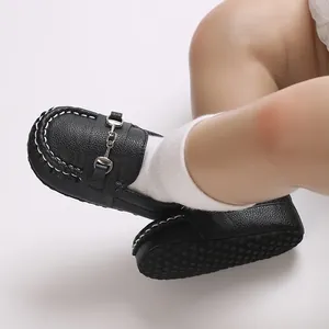 Vue détaillée de mocassins pour bébé en cuir noir avec boucle en métal et semelle souple