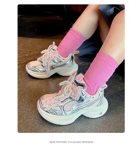 Detail of girls' pink mesh sneakers with elegant pearl and lace bow decorations.