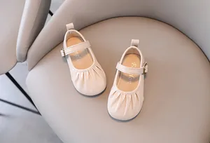 Dettaglio ravvicinato della punta arricciata e del cinturino sulle Mary Jane beige bimba