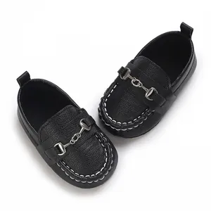 Détail de mocassins noirs pour bébé avec boucle mors argentée et surpiqûres blanches