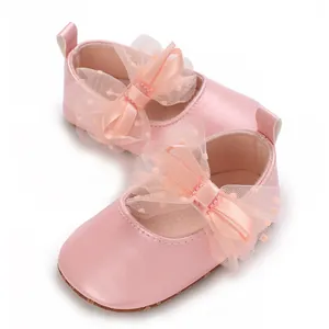 Detalle de los zapatos rosas para caminar de bebé con un gran lazo de doble capa