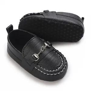 Gros plan sur les mocassins noirs pour bébé garçon avec mors argenté et semelle souple antidérapante
