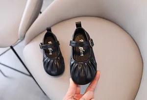 Vista dettagliata di scarpa da principessa nera per bambina con punta a pieghe