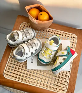 Dettaglio di scarpe primi passi traspiranti per neonato con velcro su uno sgabello