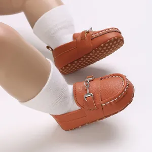 Détail de chaussures de marche marron pour bébé garçon avec boucle en métal classique