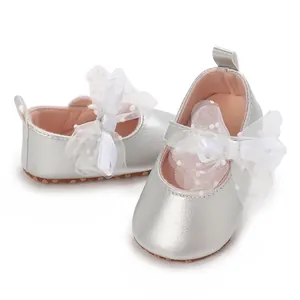 Vista detallada de zapatos de gateo para bebé en color plata con suela blanda y lazo blanco