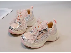 Close-up of pink girls sneakers featuring elegant pearl and lace bow decorations