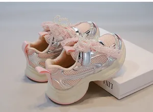 Detailed view of girls' pink mesh sneakers with lace bow and pearl butterfly