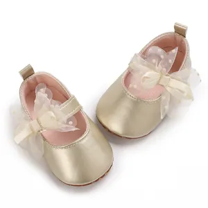 Primer plano de zapatos dorados para bebé niña con un elegante lazo de encaje crema