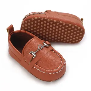 Détail de mocassins marrons pour bébé avec boucle mors et semelle antidérapante.