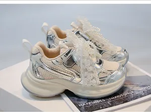 Detailed shot of girls' silver dad shoes featuring elegant pearl and lace bow decorations.