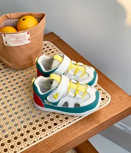 Vista laterale di sneaker per bambini con mesh e dettaglio a cuore su tavolo in rattan