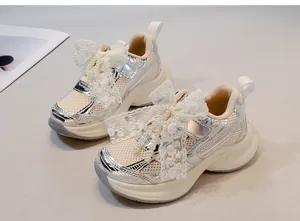 Close-up of girls' mesh sneakers with elegant lace bows and pearl details.