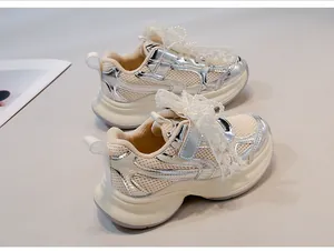 Close-up detail of silver children's chunky sneakers with pearl lace and mesh design