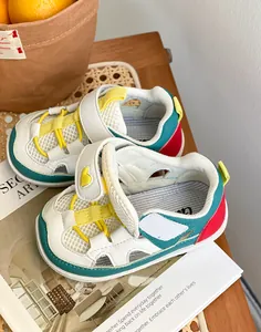 Primo piano di scarpine colorate per bambini con rete traspirante e cinturino in velcro.