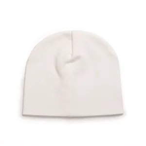 Close-up view of a soft off-white cotton beanie hat designed for newborn baby infants