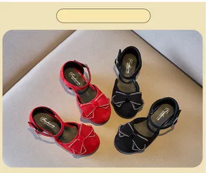 Vista detallada de elegantes zapatos de princesa para niña con lazos de pedrería en rojo y negro.