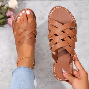 Sandales plates marron pour femmes avec brides croisées tissées pour la plage.