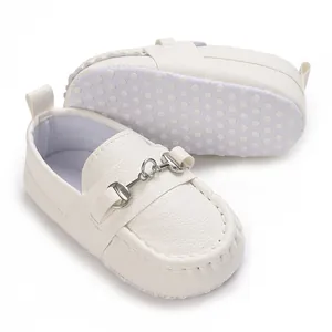 Détail de mocassins blancs pour bébé avec semelle souple antidérapante et boucle.