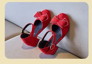Vista detallada de zapatos de gamuza roja para niña con lazo de diamantes y tacón bajo