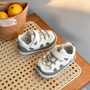 Scarpe da passeggio traspiranti per neonati bianche e grigie con motivo a cuore.