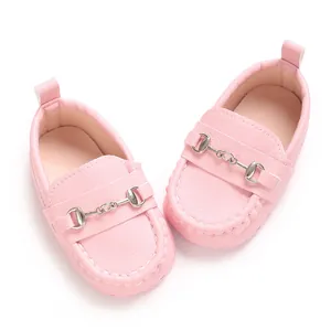 Détail de mocassins roses pour bébé avec semelle souple et boucle mors argentée