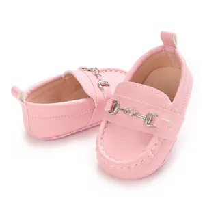 Gros plan de mocassins roses pour bébé à semelle souple avec détail mors en métal