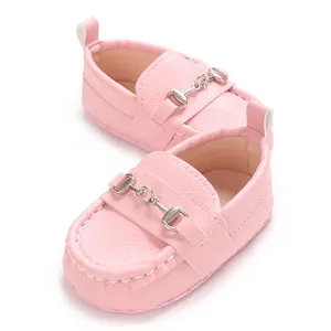 Gros plan de mocassins roses pour bébé à semelle souple avec boucle en métal argenté