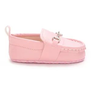 Vue de côté détaillée des mocassins roses pour bébé avec boucle en argent élégante