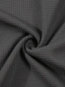Macro view showing the soft waffle knit texture of a dark gray men's long-sleeve polo shirt.