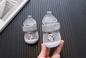 Close-up of grey cartoon infant walking shoes with anti-kick toe and velcro strap