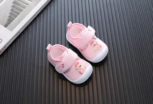 Detailed view of pink corduroy baby walking shoes with cute unicorn pattern.