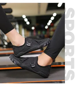 Side view detail of black breathable mesh water shoes worn on an indoor gym treadmill