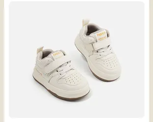 Vista detallada de zapatillas deportivas color crema para niños con velcro y cordón