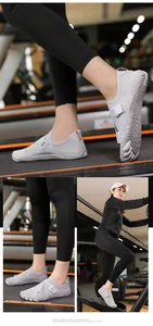 Lightweight grey barefoot fitness shoes shown in gym environment with non-slip sole