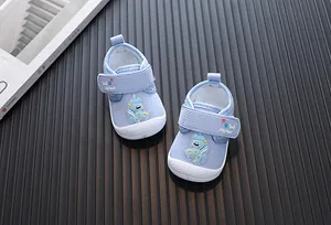 Close-up of blue corduroy baby walking shoes with cartoon elephant and velcro strap