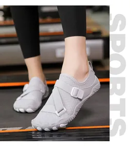 Close-up of grey non-slip water shoes with cross-straps for fitness and gym workouts.