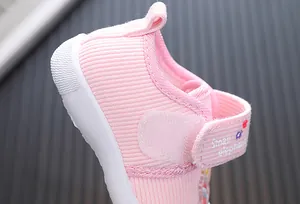 Close-up of pink baby walking shoe with small elephant printed on velcro strap
