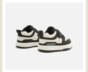 Vista posterior de zapatillas para niños en blanco y negro con el texto FASHION