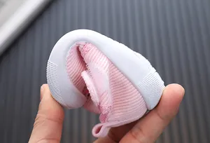 Close-up showing the extreme flexibility and soft sole of the pink baby walking shoe