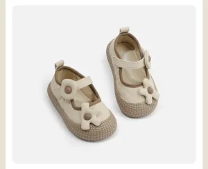 Detailoverzicht van beige babymeisjes Mary Jane schoenen met bloemen en zachte zolen.
