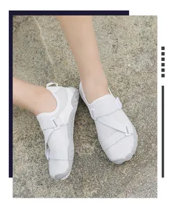 High-angle close-up of white breathable outdoor wading shoes worn on rough stone ground