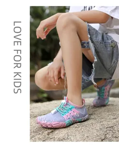 Close-up van kleurrijke antislip waterschoenen voor kinderen op een rotsachtig vlak