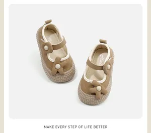 Gedetailleerd bovenaanzicht van bruine Mary Jane-schoenen voor baby's met bloemmotief.