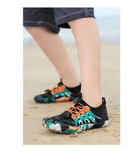 Kind draagt kleurrijke camouflage waterschoenen op het strand voor wateractiviteiten