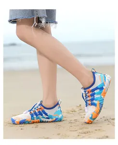 Antislip waterschoenen voor kinderen op een zandstrand om te waden